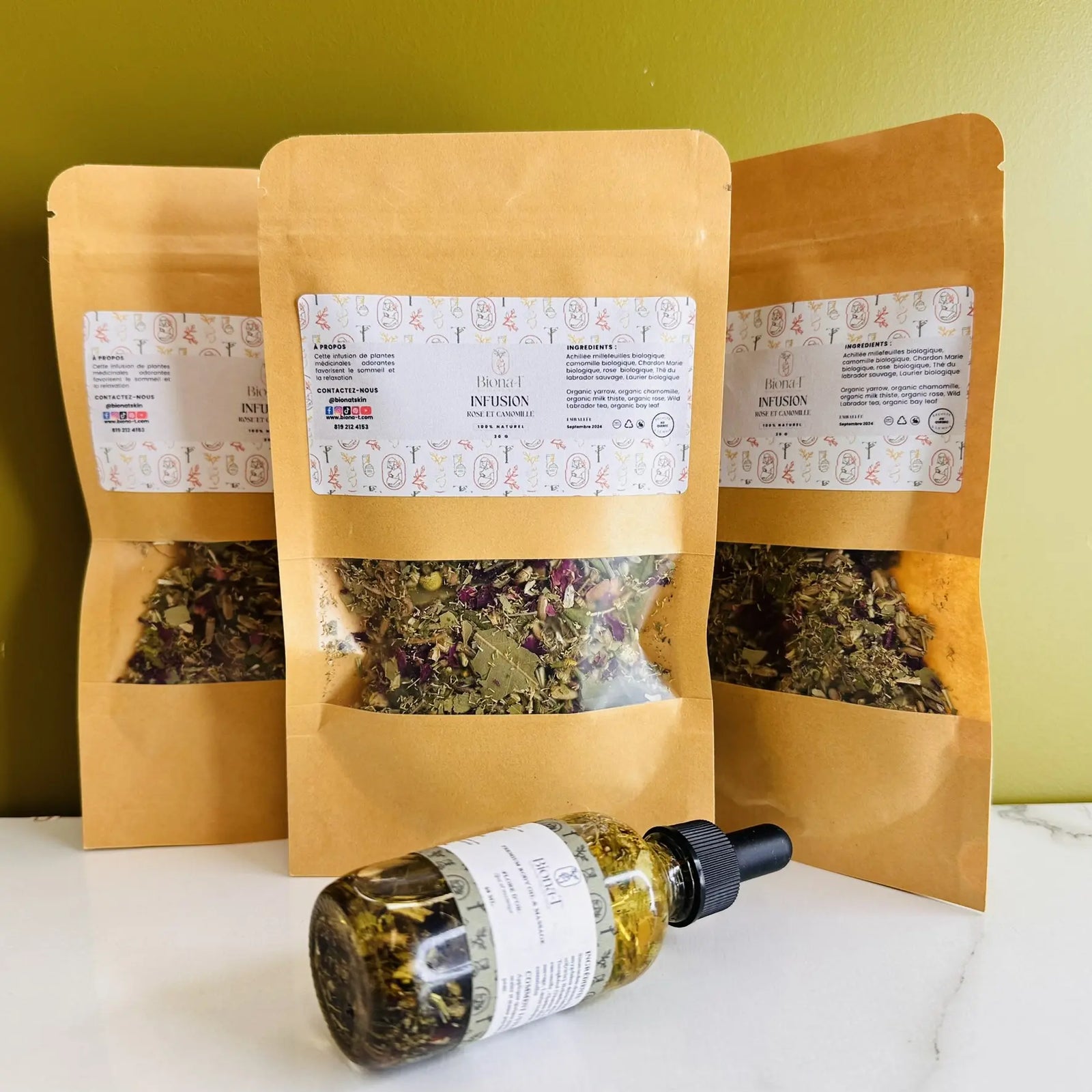 Infusion de tisane de rose et camomille et une bouteille d'huile de massage couchée