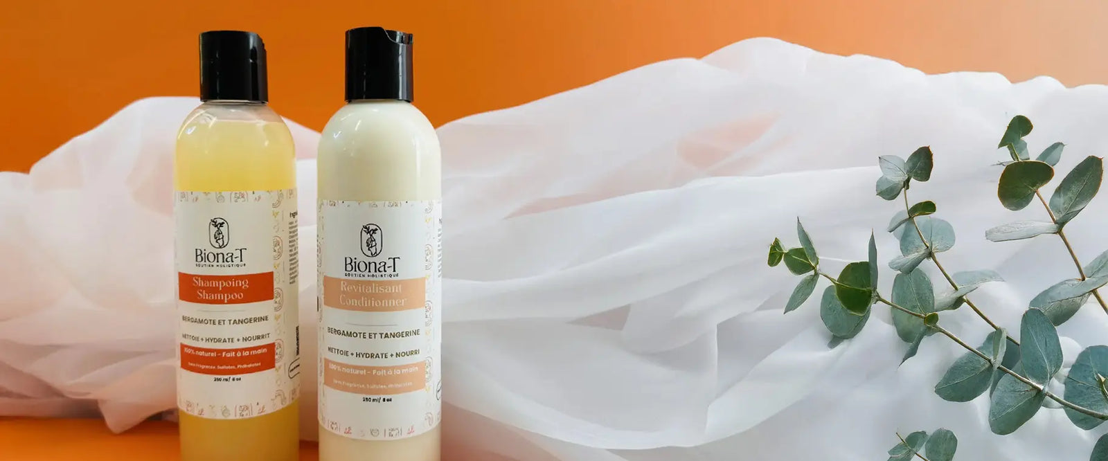 un shampoing et un revitalisant sur fond orange avec tissu et eucalyptus