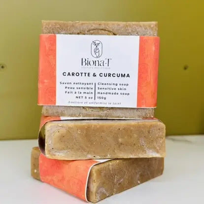 un savon artisanal carotte et curcuma sur fond vert
